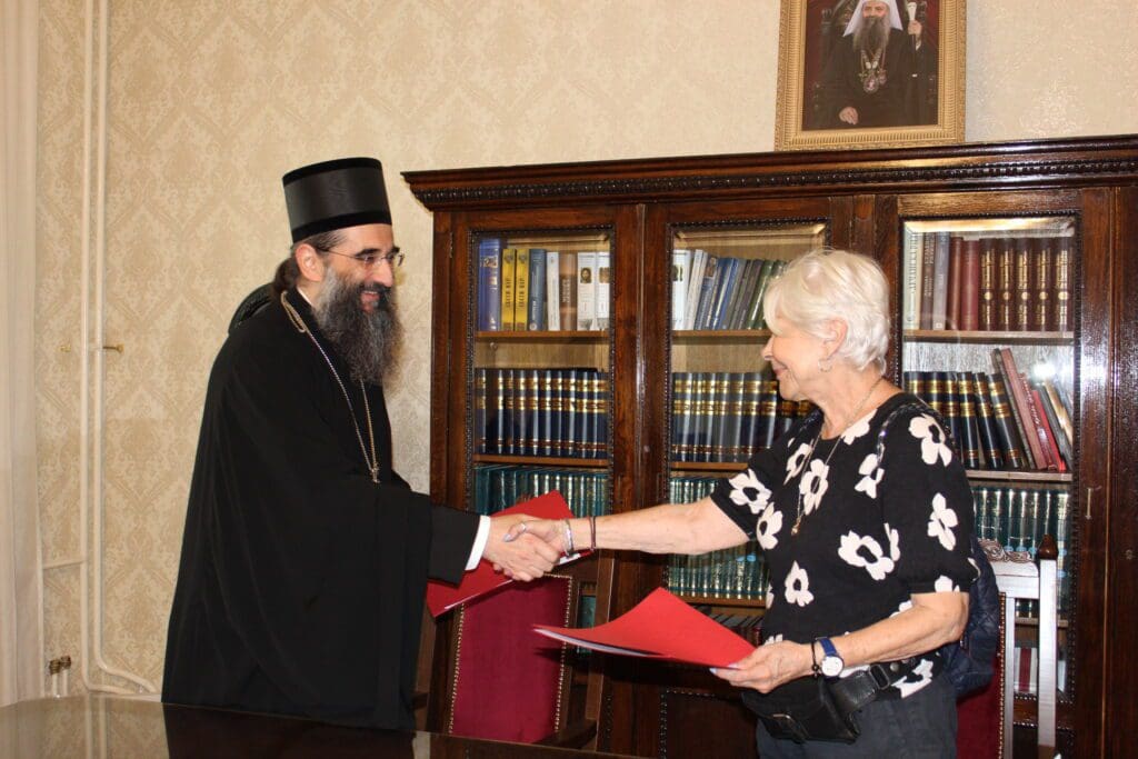 Bearded man and woman shaking hands by bookshelves