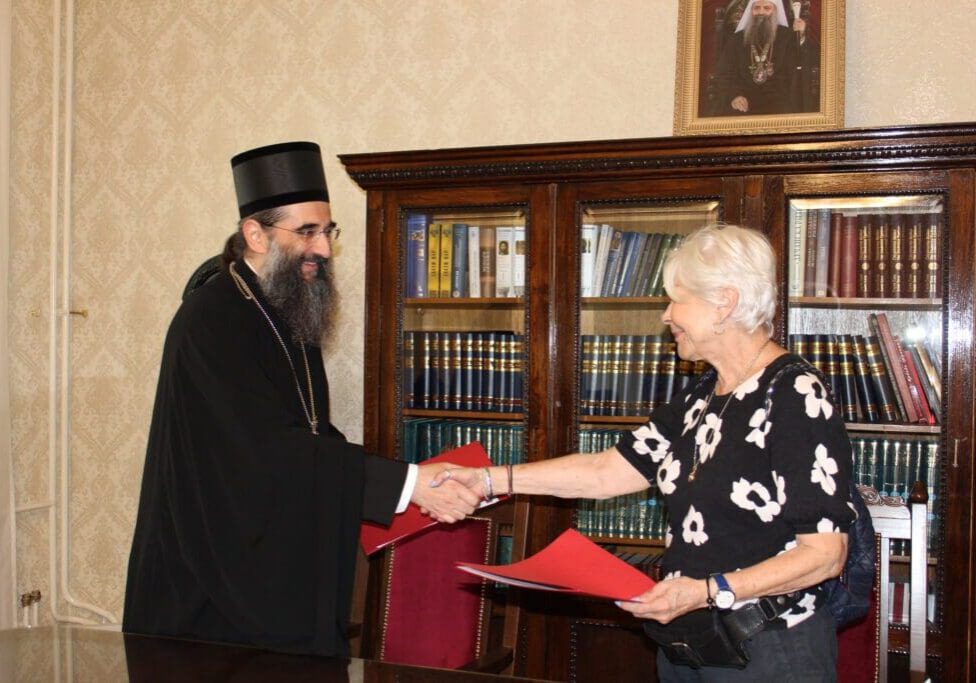 Bearded man and woman shaking hands by bookshelves